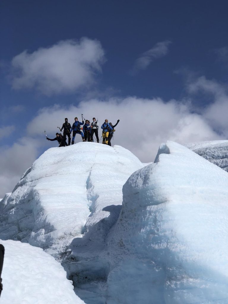 Gruppe unge mennesker på toppen av en isformasjon
