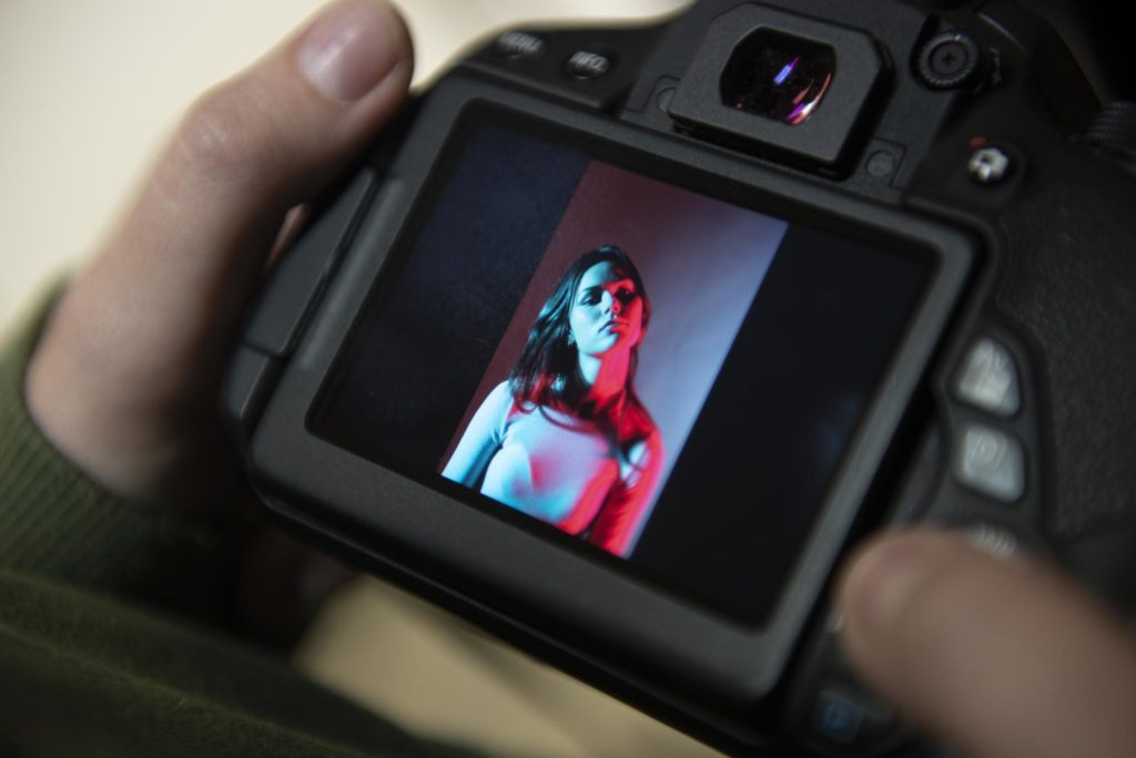 Bilde av ung kvinne i fotostudio med blått og rødt lys