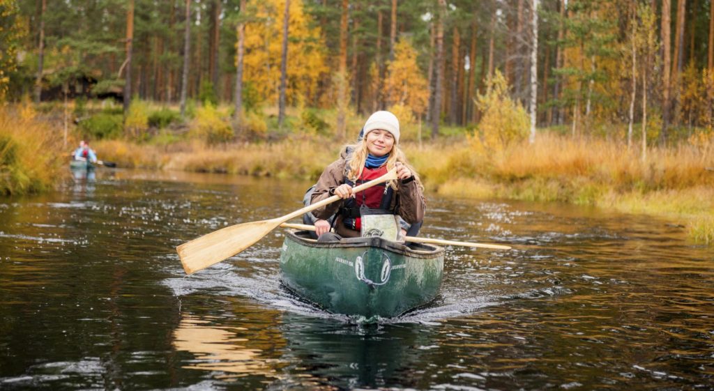 Young woman paddling in canoe