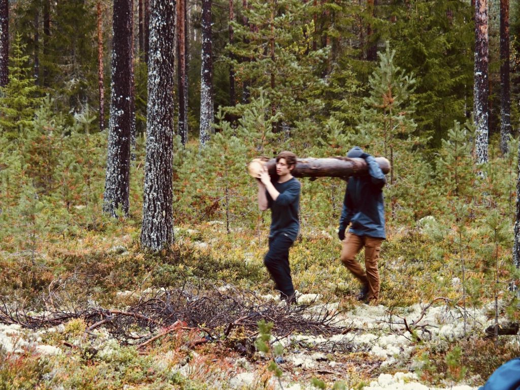 Two young men carrying a log