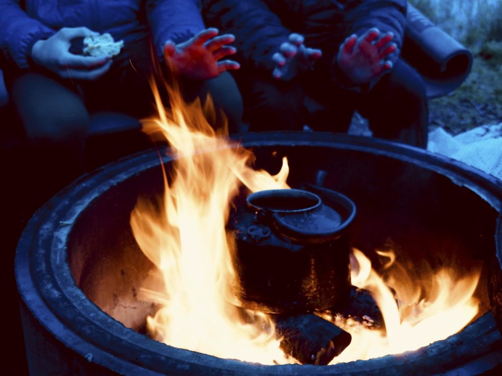 Hands are warmed by the fire