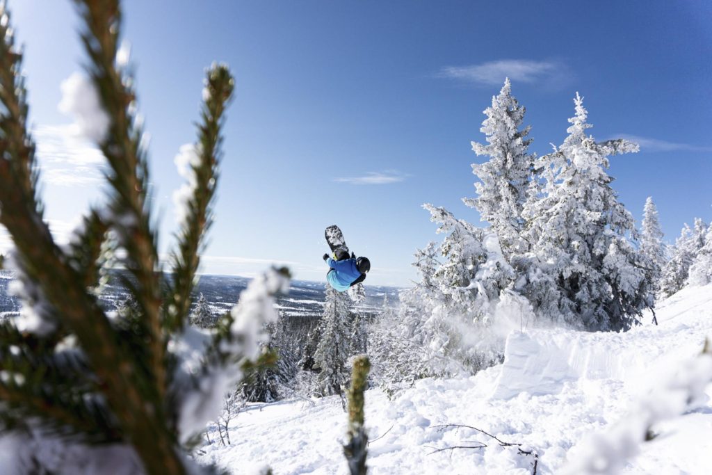 Snowboarder takes backflip In powder snow