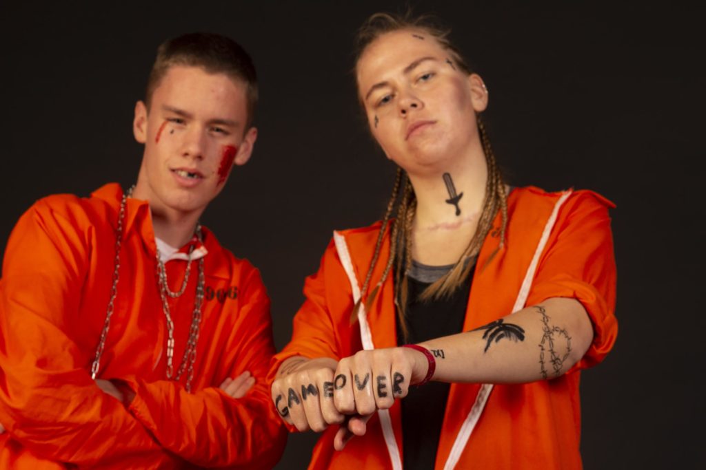 Young man and woman dressed as Orange is the new black