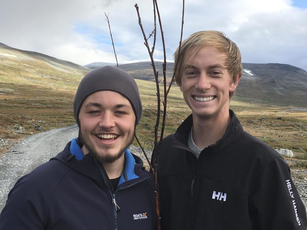 To unge menn smiler på fjelltur
