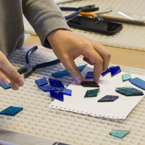 Hender jobber med biter av glass