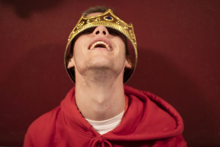 Ung mann kledd ut som konge smiler